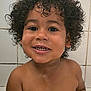 child, toddler, curly_hair, smiling, teeth, bathroom, tile_wall, water_droplets, bare_shoulders, happy, cute, face, skin, young_child, indoors, portrait, closeup, person, wet_skin, joyful