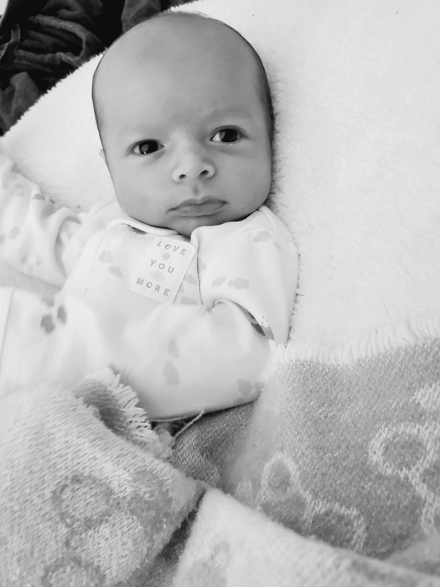 Nikolas is registered to the contest to win money with this photo: baby, baby_toddler_clothing, cheek, child, comfort, eyebrow, face, flash_photography, fur, happy, human_body, iris, linens, lip, monochrome, monochrome_photography, nose, person, skin, sleeve