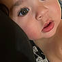 baby, close_up, face, child, eyes, rosy_cheeks, curious, portrait, infant, skin, eyelashes, lips, cute, soft_lighting, head, resting, black_background, young_child, expression, adorable