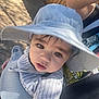 baby, casual, child, closeup, curious, cute, eyes, face, hat, infant, outdoor, person, shadow, striped_clothing, stroller, summer, sun_hat, sunlight, toddler, wooden_fence