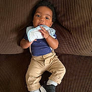 Corey joined the competition — help win amazing prizes! baby, child, infant, couch, brown, cloth, sitting, sneakers, suspenders, pants, blue_shirt, cute, indoors, portrait, face, hand, footwear, comfortable, young, fashion