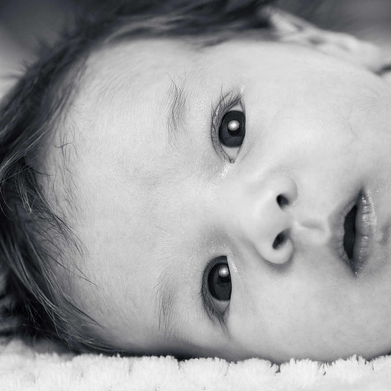 Tim participe au concours pour gagner de l'argent avec cette photo : baby, black_and_white, close_up, cute, expression, eyes, face, hair, head, infant, innocence, laying_down, monochrome, newborn, person, portrait, skin, sleepwear, soft_texture, young_child