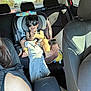 toddler, child, car_seat, sunglasses, clapping, car_interior, family, smiling, seatbelt, blanket, toy, adult, window, sunlight, headrest, backseat, person, casual_clothing, happy, travel