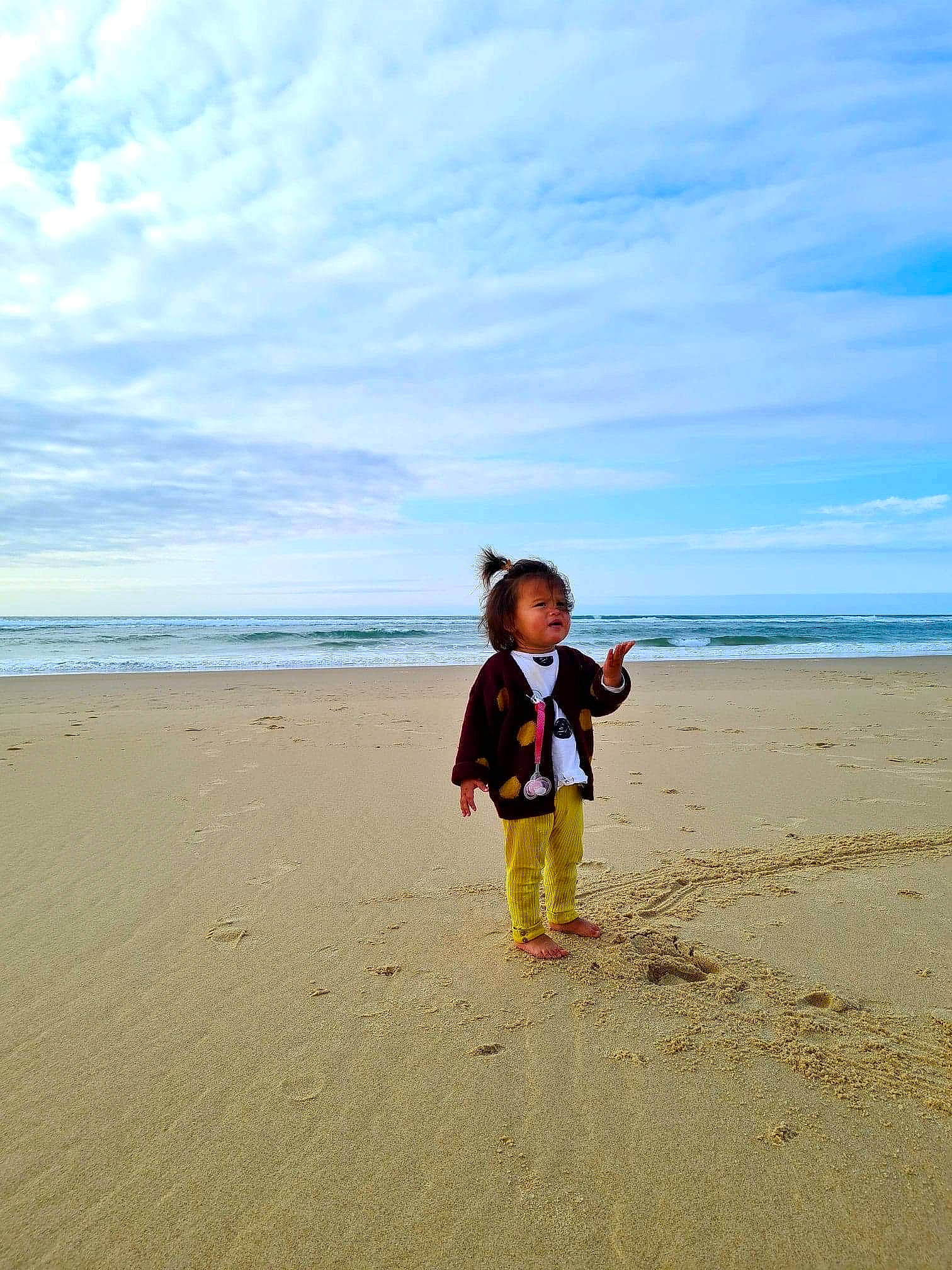 Lou-maï a rejoint le concours — aidez-le/la à gagner de superbes lots ! baby_toddler_clothing, beach, child, cloud, coast, coastal_and_oceanic_landforms, footprint, holiday, horizon, ocean, people_in_nature, people_on_beach, person, sand, sea, shore, singing_sand, summer, toddler, tropics