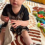 Brynlee is registered to the contest to win money with this photo: toddler, child, baby, indoor, play_mat, toy, clothing, sitting, hand, face, shoe, floor, pattern, curious, soft_lighting, blanket, person, room, playtime, cute