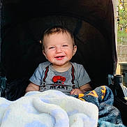 Arnold is registered to the contest to win money with this photo: baby, smiling, stroller, blanket, child, cute, happy, infant, portrait, clothing, indoor, face, head, toddler, toy, warm, cozy, cute_expression, person, baby_boy