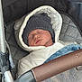 baby, sleeping, stroller, hat, blanket, jacket, child, infant, cozy, portrait, closeup, outdoor_gear, warm_clothing, rest, cute, newborn, soft, comfort, transport, baby_carriage