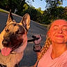 braid, canine, casual_clothing, dog, exercise, friendship, german_shepherd, happy, leash, nature, outdoor, pet, portrait, recreation, road, smiling, sunlight, sunset, trees, woman