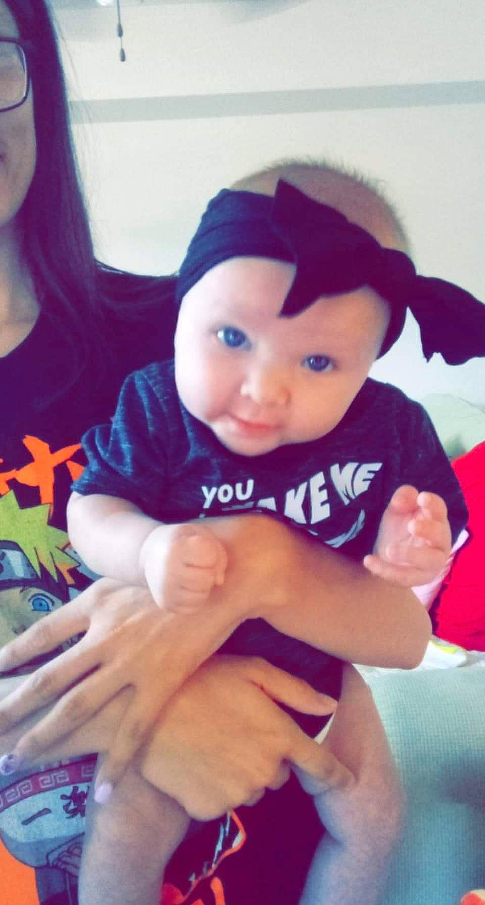 Octavia is registered to the contest to win money with this photo: arm, baby_toddler_clothing, cheek, clothing, face, facial_expression, finger, gesture, hairstyle, hand, happy, head, headwear, lip, mammal, muscle, person, purple, skin, sleeve