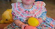 Juniper joined the competition — help win amazing prizes! baby, child, dress, floral_pattern, lace, pink, yellow, easter_eggs, toy, plush, carpet, indoor, cute, smiling, portrait, sitting, person, blue_eyes, hands, feet