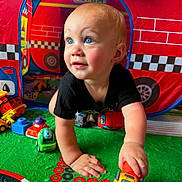 Asher joined the competition — help win amazing prizes! toddler, child, toy, toy_truck, play_mat, play_tent, crawling, blue_eyes, indoor, colorful, red, yellow, black_shirt, car_toy, floor, hand, face, person, smiling, young_child