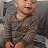 baby, bed, bedroom, blanket, candid, child, clothing, cozy, face, happy, indoor, infant, person, photography, pillow, portrait, sitting, smiling, sock, striped_pajamas