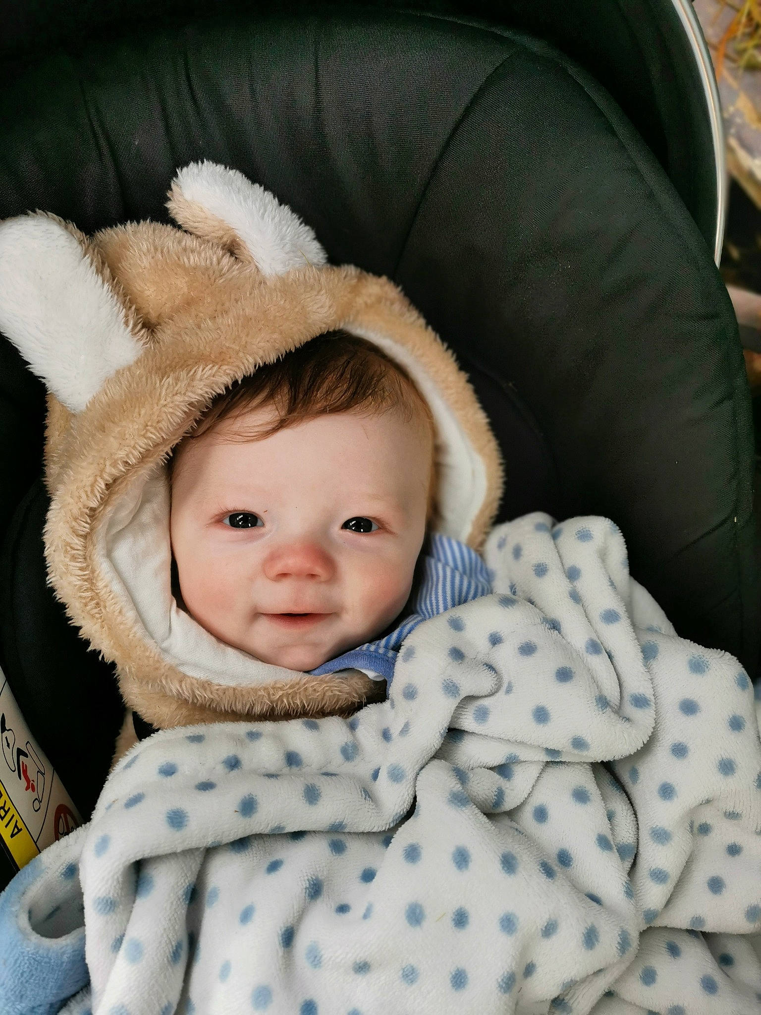 Rory joined the competition — help win amazing prizes! baby, baby_toddler_clothing, cap, cheek, child, comfort, fur, happy, iris, knit_cap, linens, pattern, person, sitting, skin, sleeve, smile, textile, toddler, white
