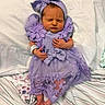 newborn, baby, sleeping, portrait, purple_outfit, dress, headband, bow, ruffles, flowers, hospital_bracelet, blanket, bedding, pillow, striped_fabric, lying_down, closed_eyes, hands, feet, indoor