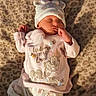 Violet is registered to the contest to win money with this photo: newborn, baby, sleeping, infant, portrait, indoors, blanket, leopard_print, pajamas, onesie, hat, mittens, socks, clothing, bed, cozy, peaceful, face, textile, warm_lighting