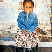 Ennsley joined the competition — help win amazing prizes! child, smiling, denim_jacket, skirt, animal_print, sitting, stool, winter_background, snow, trees, lanterns, portrait, happy, fashion, indoor, photography, cute, girl, young_child, colorful