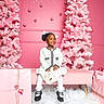 Ennsley joined the competition — help win amazing prizes! child, girl, smiling, pink, christmas_tree, holiday, gift_box, present, decorations, white_clothing, black_shoes, ribbons, ornaments, bench, snow, indoor, festive, celebration, portrait, happy