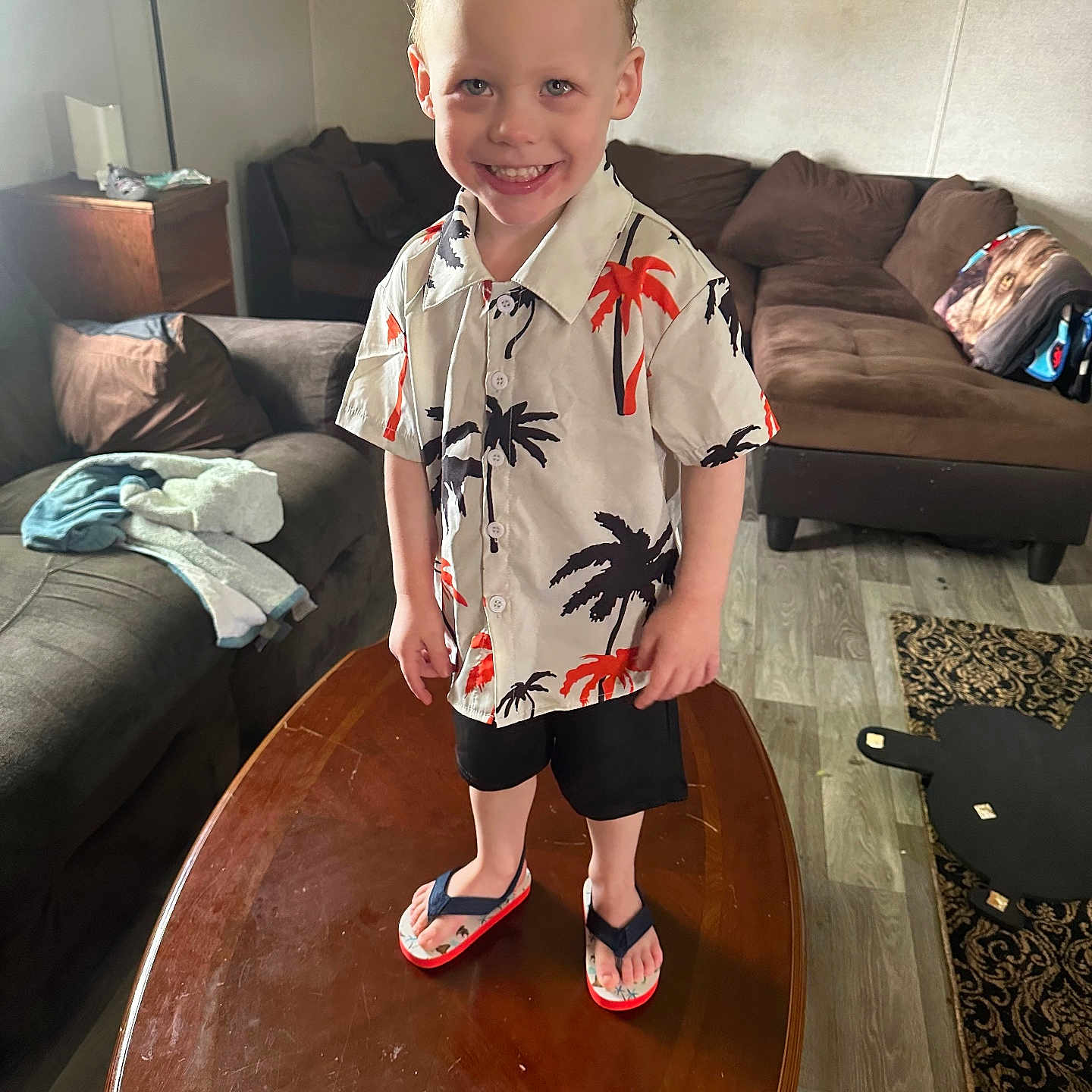Kyson is registered to the contest to win money with this photo: accessories, bag, beachwear, boy, child, clothing, couch, footwear, furniture, handbag, head, male, person, sandal, shoe, shorts, sitting, sleeve, standing, table