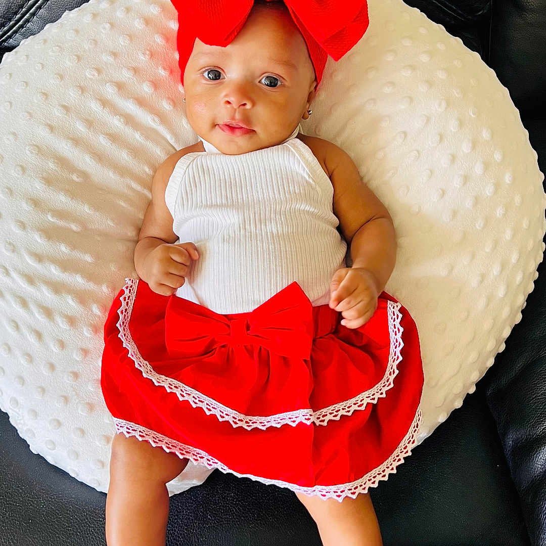 Ruby is registered to the contest to win money with this photo: baby, clothing, costume, cushion, dress, face, footwear, furniture, hat, head, homedecor, hosiery, pants, person, photography, portrait, shoe, sitting, sock, symbol