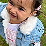 toddler, child, smiling, denim_jacket, pink_hair_clip, grass, outdoor, cute, happy, portrait, fashion, small_child, pink_shoes, white_fur_collar, casual_clothing, nature, young_child, joyful, standing, daylight