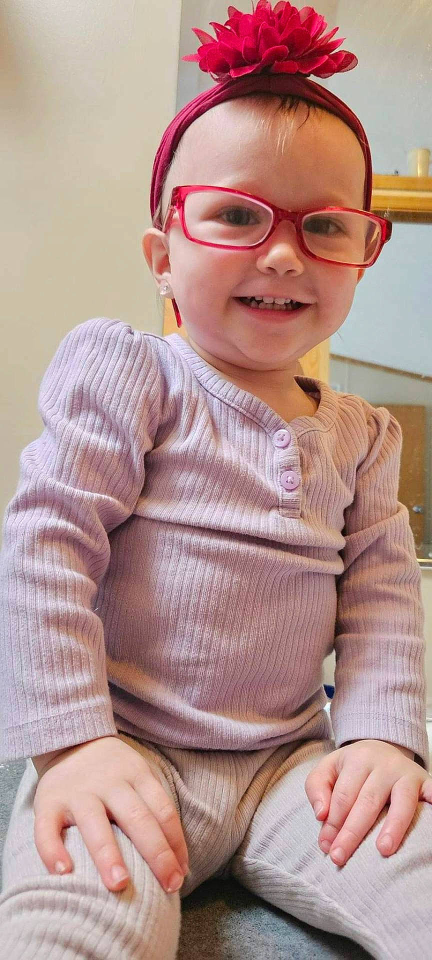 Mckenna Rose is registered to the contest to win money with this photo: accessories, baby, bodypart, clothing, face, finger, glasses, hand, happy, head, jewelry, knitwear, pants, person, photography, portrait, sitting, sleeve, smile, sweater