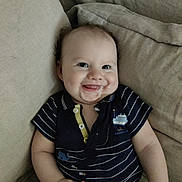 Oscar a rejoint le concours — aidez-le/la à gagner de superbes lots ! baby, child, smiling, drool, couch, striped_clothing, navy_blue, onesie, nautical, happy, infant, cute, indoor, portrait, sitting, person, face, young_child, relaxed, comfort