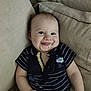 baby, child, smiling, drool, couch, striped_clothing, navy_blue, onesie, nautical, happy, infant, cute, indoor, portrait, sitting, person, face, young_child, relaxed, comfort