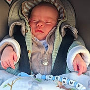 Lenny a rejoint le concours — aidez-le/la à gagner de superbes lots ! baby, sleeping, car_seat, blanket, pacifier, beads, child, infant, warm_clothing, hood, zipped_jacket, hands, cute, peaceful, soft_texture, indoor, closeup, portrait, child_safety, resting