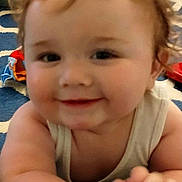 Eric joined the competition — help win amazing prizes! baby, child, curly_hair, smiling, indoor, carpet, toy, hand, face, cheeks, person, crawling, infant, cute, closeup, skin, clothing, background, happy, young