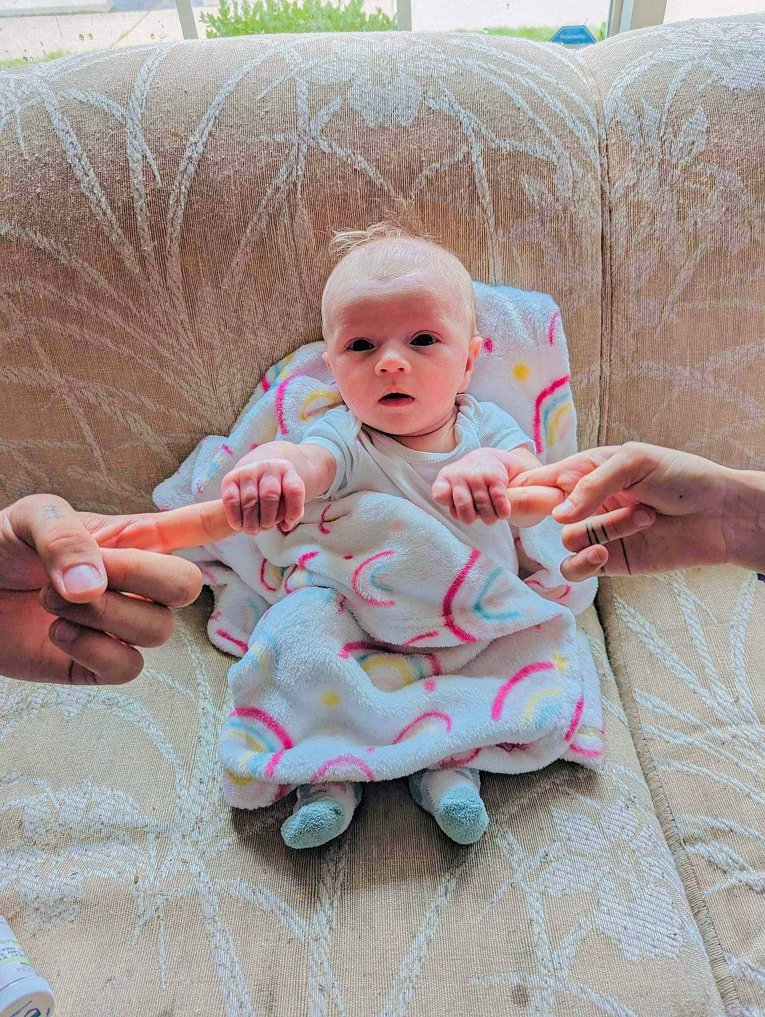 Esmeralda is registered to the contest to win money with this photo: baby, baby_products, baby_toddler_clothing, cheek, child, comfort, couch, eye, flooring, foot, grass, hand, linens, pattern, person, room, sitting, skin, sock, toddler