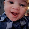 Bradley is registered to the contest to win money with this photo: baby, smiling, face, child, portrait, indoor, checkered_shirt, happy, closeup, person, young, cute, head, eyes, mouth, clothing, infant, human, baby_boy, joyful