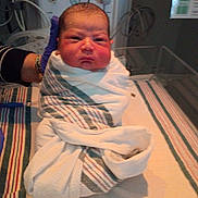 Robert is registered to the contest to win money with this photo: newborn, baby, infant, hospital, swaddled, blanket, medical_equipment, gloved_hand, bed, striped_blanket, person, face, portrait, healthcare, clinic, newborn_care, baby_wrapped, indoor, patient, child