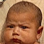 Robert is registered to the contest to win money with this photo: baby, face, close_up, expression, furrowed_brow, skin, head, child, portrait, young, human, infant, serious, indoor, person, cute, chubby_cheeks, curious, looking, photography