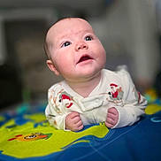Layla joined the competition — help win amazing prizes! baby, child, close_up, colorful, curious, cute, expression, eyes, face, hands, head, indoors, infant, lying_down, mouth, pajamas, play_mat, skin, soft_focus, young