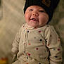 baby, child, smiling, face, hat, knit_hat, onesie, polka_dot, cozy, indoor, cute, chubby, infant, portrait, warm_clothing, happy, sitting, headwear, soft_lighting, closeup