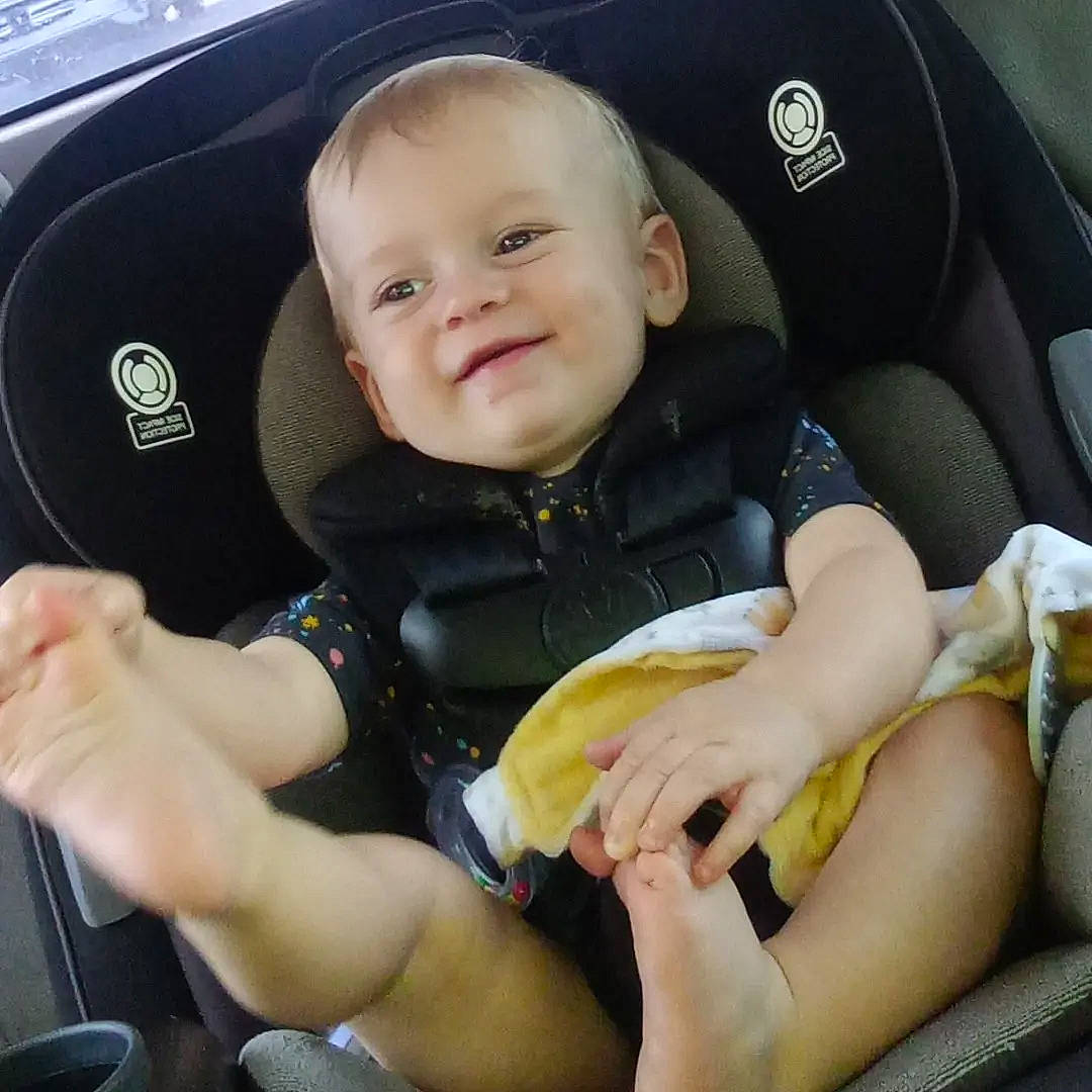 Kolten is registered to the contest to win money with this photo: arm, baby, baby_carriage, baby_in_car_seat, baby_toddler_clothing, car_seat, car_seat_cover, comfort, finger, gesture, hand, joy, person, product, seat_belt, smile, steering_wheel, thigh, thumb, toddler