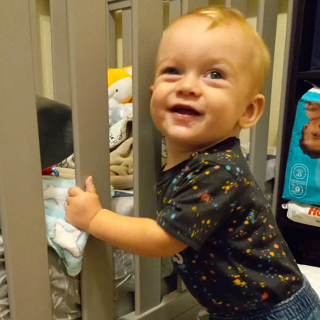 Kolten is registered to the contest to win money with this photo: baby, baby_toddler_clothing, cheek, child, elbow, finger, fun, happy, iris, joy, nose, pattern, person, play, room, skin, sleeve, smile, standing, t_shirt