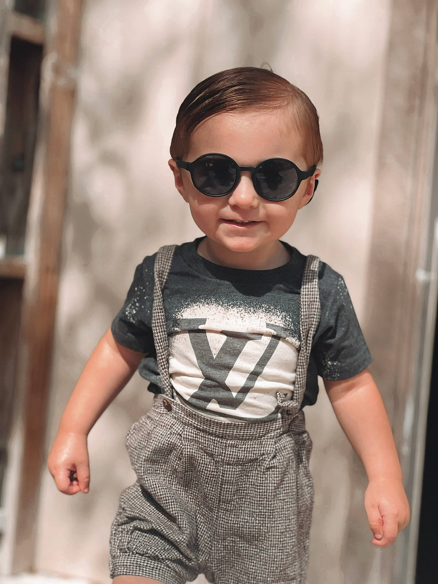Bentley is registered to the contest to win money with this photo: baby_toddler_clothing, cool, eyewear, face, facial_expression, fashion, fashion_design, glasses, goggles, joint, neck, person, shoulder, sleeve, standing, street_fashion, style, sunglasses, t_shirt, vision_care