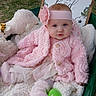 April joined the competition — help win amazing prizes! baby, pink_clothing, headband, plush_toy, blanket, outdoor, grass, sign, text, sheep_toy, boots, cute, portrait, child, infant, soft_texture, decor, sitting, flower, headwear