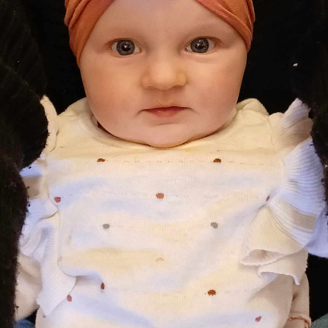 Léna a rejoint le concours — aidez-le/la à gagner de superbes lots ! baby, baby_toddler_clothing, cap, cheek, chin, eye, eyebrow, forehead, head, headgear, iris, lip, nose, pink, skin, sleeve, smile, textile, toddler, white