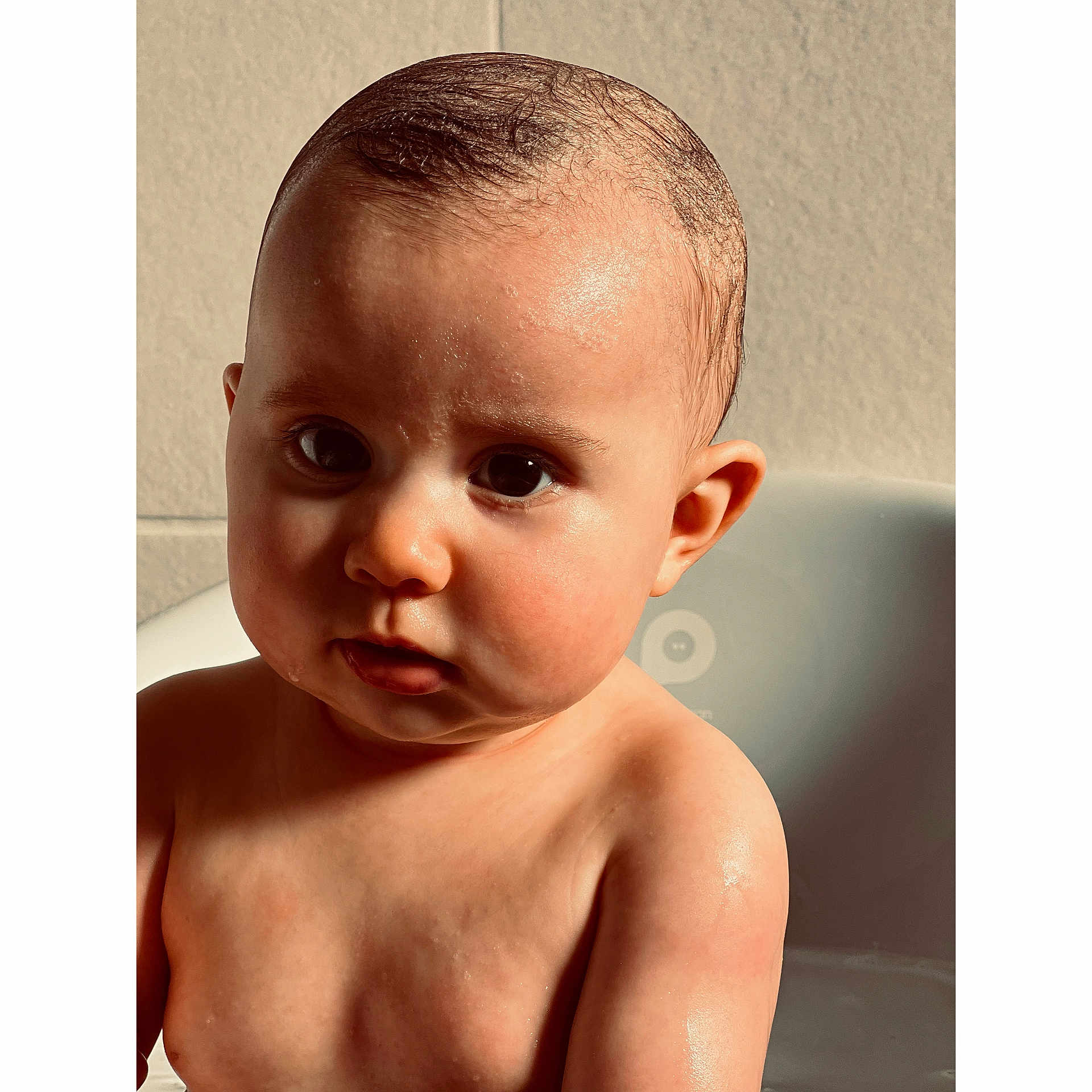 Lou participe au concours pour gagner de l'argent avec cette photo : baby, child, bathtub, wet, skin, face, eyes, curious, portrait, indoor, light, shadow, head, shoulders, water, young, cute, expression, bath, person
