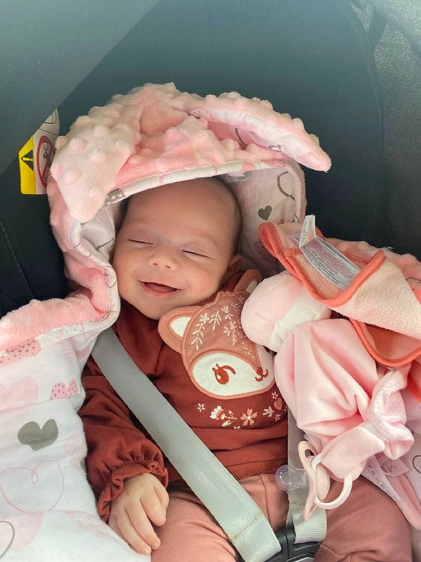 Clara participe au concours pour gagner de l'argent avec cette photo : baby, baby_carriage, baby_products, baby_toddler_clothing, cheek, chin, comfort, eye, happy, head, headwear, human_body, iris, lip, mouth, nose, person, pink, skin, sleeve