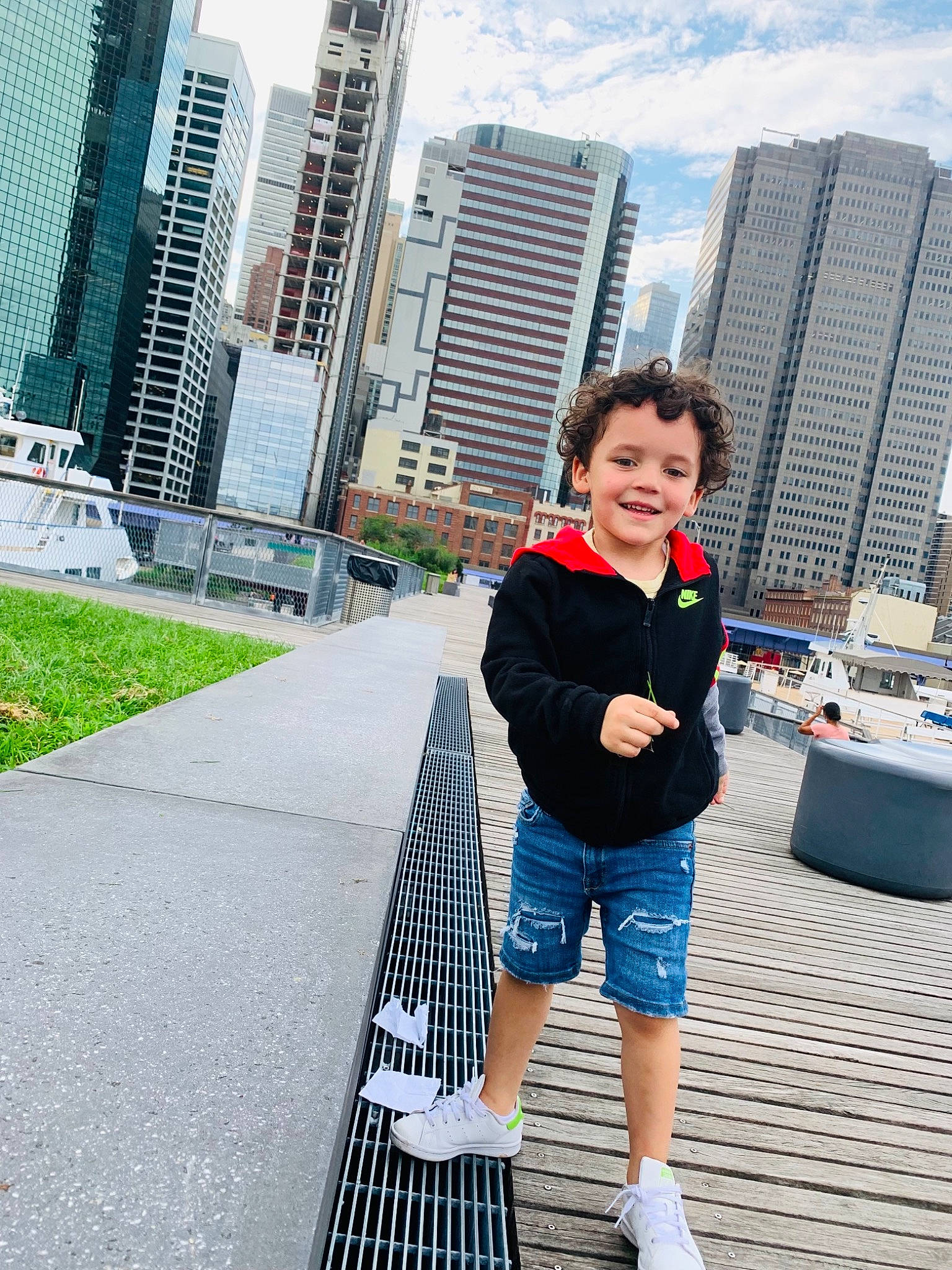 Zyan is registered to the contest to win money with this photo: architecture, asphalt, building, city, cityscape, condominium, electric_blue, human_leg, infrastructure, joy, leisure, pedestrian, person, recreation, shorts, sky, skyscraper, street_fashion, toddler, tower