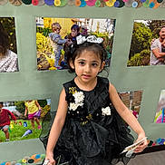 Nimal joined the competition — help win amazing prizes! child, girl, dress, black_dress, headband, gift_bag, indoor, floor, photography, portrait, smile, celebration, party, decoration, colorful, wall, photo_display, young, person, footwear