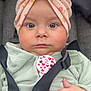baby, bow, car_seat, child, closeup, clothing, cute, expression, eyes, face, floral, hand, headwrap, indoors, infant, person, pink, seatbelt, skin, straps