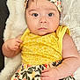 Anaé participe au concours pour gagner de l'argent avec cette photo : baby, infant, child, headband, yellow_clothing, floral_pattern, soft_blanket, portrait, cute, skin, face, hand, expression, indoors, closeup, young_child, comfort, lying_down, apparel, adorable