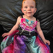 Willow joined the competition — help win amazing prizes! child, red_hair, face_paint, dress, spider_web, bat, moon, smiling, sitting, couch, leather, colorful, costume, portrait, indoors, young_child, happy, cute, holiday, celebration