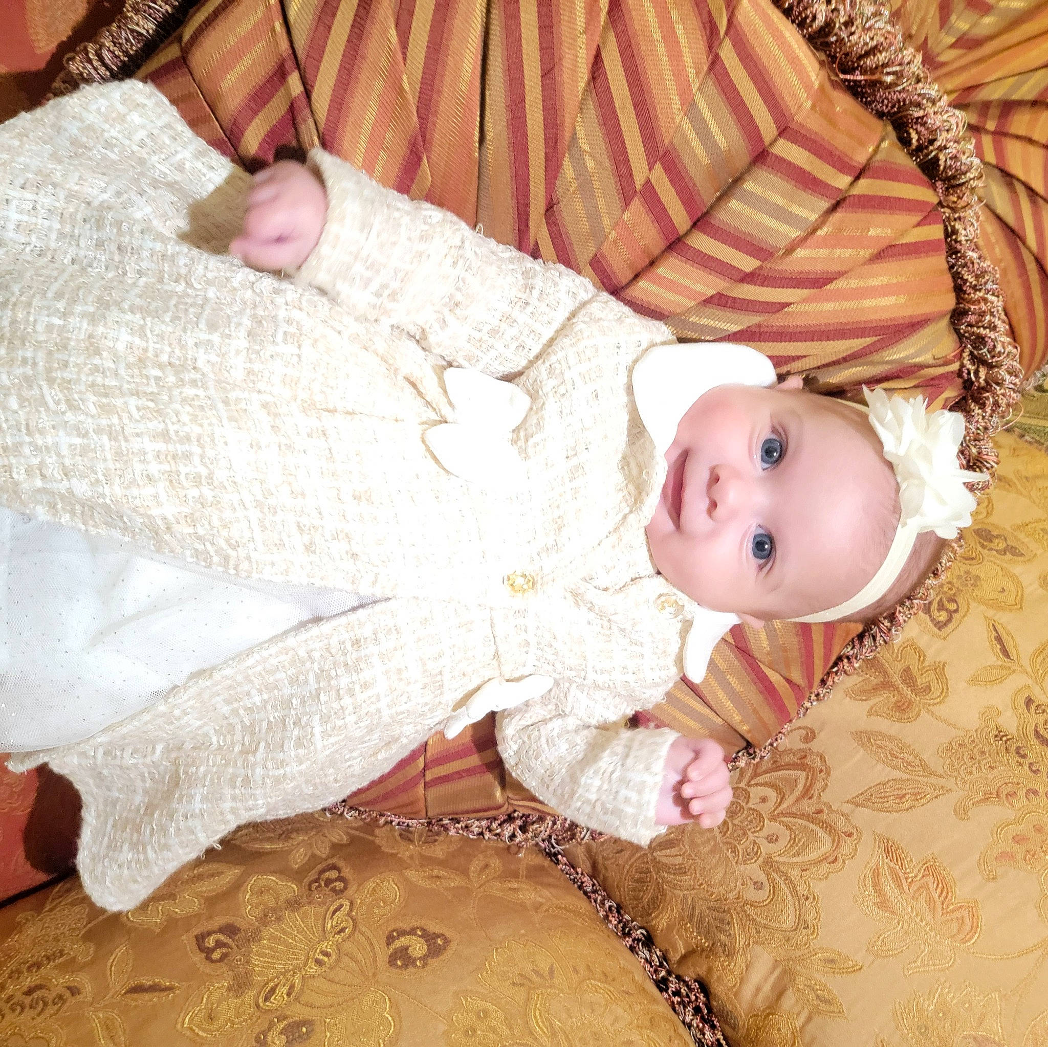 Brianna is registered to the contest to win money with this photo: baby, baby_toddler_clothing, child, comfort, embellishment, eye, facial_expression, fashion_accessory, happy, head, headgear, human_body, iris, linens, pattern, person, skin, sleeve, smile, toddler