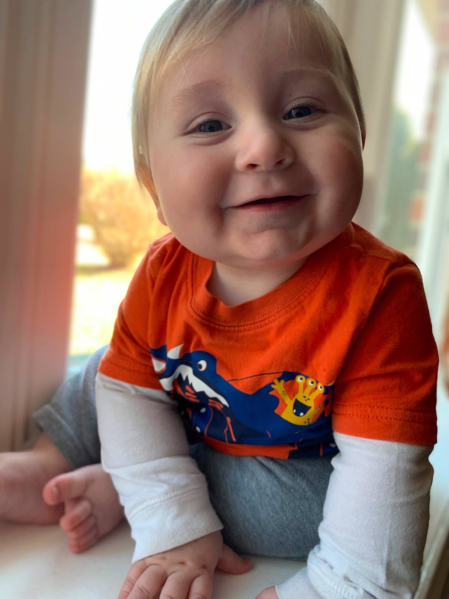 Leonard is registered to the contest to win money with this photo: baby, baby_toddler_clothing, cheek, chin, facial_expression, finger, hand, happy, head, iris, joy, lip, mouth, neck, nose, person, skin, sleeve, smile, standing