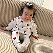 Romy participe au concours pour gagner de l'argent avec cette photo : child, baby, infant, couch, sofa, heart_pattern, sweater, leggings, bow, curly_hair, smile, blue_eyes, socks, indoors, portrait, soft_furniture, cozy, cute, window, playful